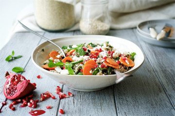Carrot salad with a mixture of grains, mint and pomegranate. The concept of healthy,  seasonal food 
