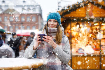 woman drinking hot punch on German Christmas market.