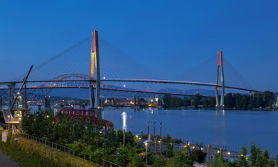 Pattullo Bridge, Sky Train Bridge  and Railroad Track over the Fraser River between New Westminster and Surrey, Promenade quay at Fraser River in New Westminster city in night time.  British Columbia 