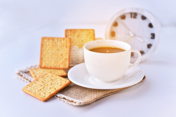 Coffee cup with square biscuits in the morning light