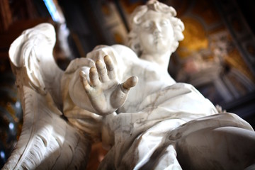 Detail of the hand of an ancient statue of an angel; concept photo to express ideas like "stop", "touch", "take".