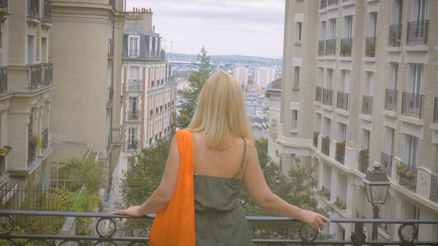 A woman watches Paris from a viewing platform on the Montmartre