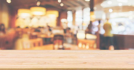 Restaurant interior with customer and wood table top over blur abstract background with bokeh light