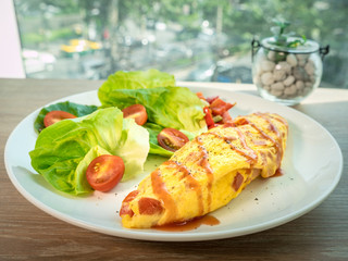 French Omelet with vegetable and salad, new menu design for healthy. Mix tomato, vegetable and seasoning when fried eggs. Fresh salad is compatible in same dish. A special meal for weight control.