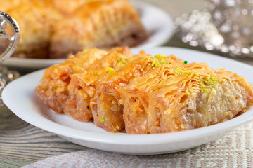 A piece of baklawa on a  plate on a  table, top view, baklava, feast treat ramadan traditional dessert