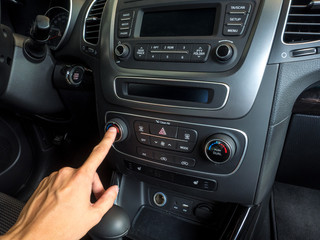Obraz na płótnie Canvas male hand pressing button in modern car. Hand on the dashboard in a car