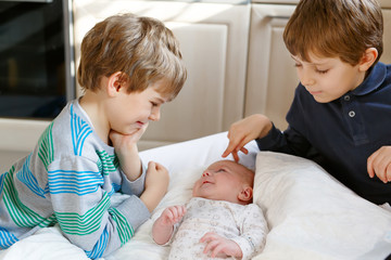 Two little kids boys playing with newborn baby sister girl © Irina Schmidt