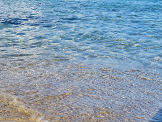 Shot of the waves on sand at the beautiful tropical San Lorenzo beach near Syracuse in a sunny day of summer