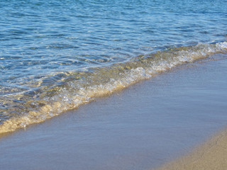 Shot of the waves on sand at the beautiful tropical San Lorenzo beach near Syracuse in a sunny day of summer