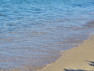 Shot of the waves on sand at the beautiful tropical San Lorenzo beach near Syracuse in a sunny day of summer