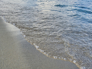 Shot of the waves on sand at the beautiful tropical San Lorenzo beach near Syracuse in a sunny day of summer