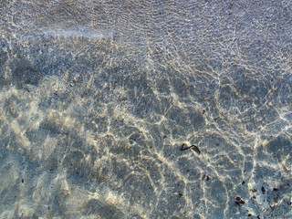 Shot of the waves on sand at the beautiful tropical San Lorenzo beach near Syracuse in a sunny day of summer