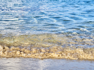 Shot of the waves on sand at the beautiful tropical San Lorenzo beach near Syracuse in a sunny day of summer