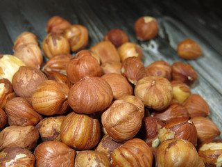 Hazelnuts on dark wooden table close-up. Heap of raw filbert nuts, protein healthy food