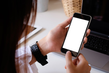 Top view a woman using mockup smartphone mobile with clipping path on office table.