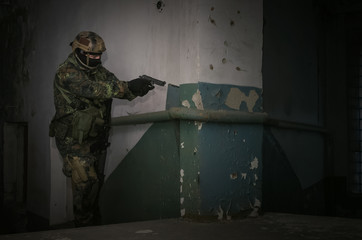 A army soldier takes aim with a pistol gun in his hands. Storming the building concept.