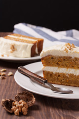 Сarrot cake with cream cheese and nuts on a wooden background
