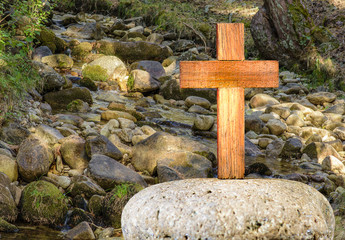 Wooden Cross on a rock with stone background