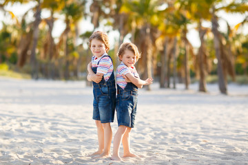 Two little kids boys having fun on tropical beach