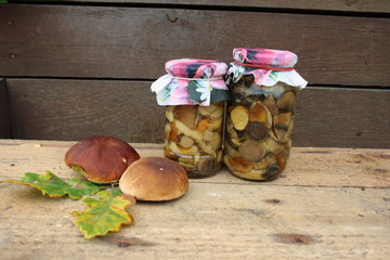 Słoiki z marynowanymi grzybami na drewniamy tle © Monika
