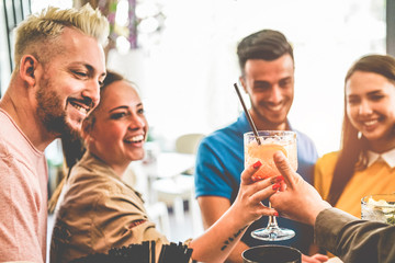 Happy young couples having fun at american bar laughing and drinking cocktails