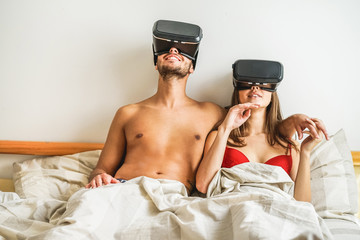 Young using virtual reality glasses for sex in bedroom