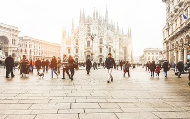 Fototapeta premium Zamazani ludzie idący przed placem Duomo w Mediolanie - Nieostry tłum w centrum włoskiej metropolii