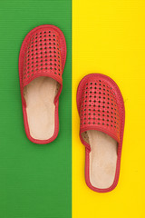 Red women's slippers on a colored background