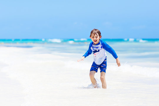 little blond kid boy having fun on tropical beach of Maldives