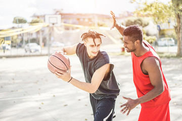 Happy athletes friends playing basketball outdoor in city urban contest