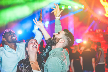 Crazy millennials friends dancing with laser lights in night club