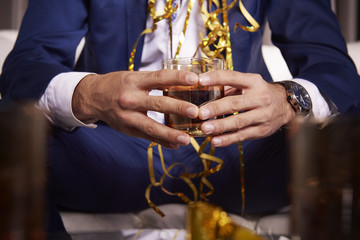 Unrecognizable man holding glass of whiskey