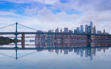 Naklejka premium Brooklyn Bridge in New York City at clounds sky, Skyline of downtown New York, USA