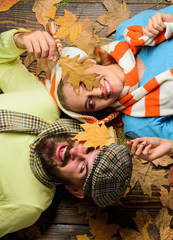 Man bearded cheerful face and lady lay on wooden background with leaves top view. Couple in love in playful mood enjoy autumn cozy season. Autumn date concept. Fall date pleasant cozy atmosphere