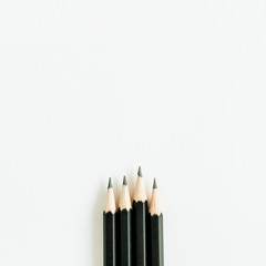 Black pencils isolated on white background. Flat lay, top view.