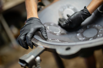 Hands designing handpan