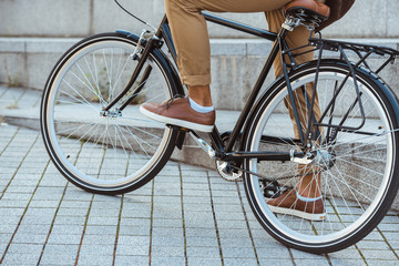 cropped shot of man riding bicycle on street