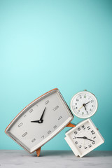 Retro alarm clocks tilted and stacked time concept on vintage blue background