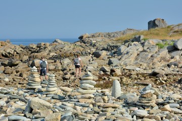 Galets en équilibre et jeune gens qui escaladent les rochers en Bretagne.France