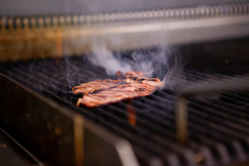 Delicious smoked bacon on grill in kitchen restaurant. Food preparation