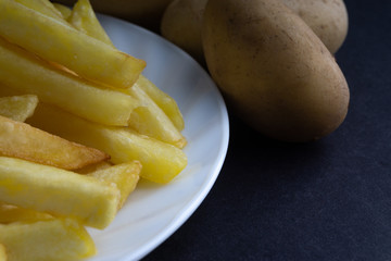 Potato fry on dark background with selective focus and crop fragment