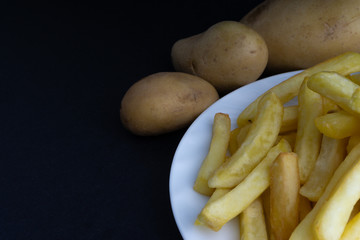 Potato fry on dark background with selective focus and crop fragment