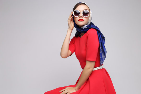 Young woman in retro style. Sunglasses and silk scarf.