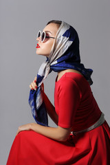 Young woman in retro style. Sunglasses and silk scarf.