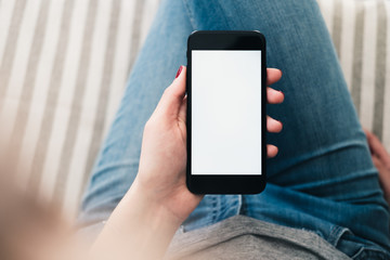 Close-up view of woman's hand holding smartphone with blank white screen. Horizontal mockup design. Mobile app demonstration concept.