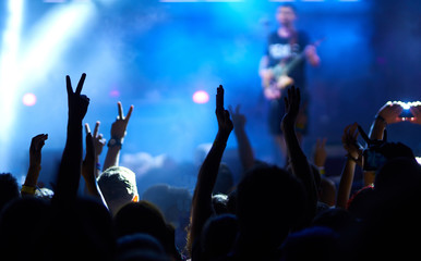 the guys put their hands up and enjoy the music. crowd at concert - summer music festival.