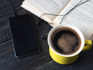Audio book concept. Headphones, coffee and book over wooden table