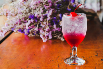 Close up Strawberry Italian soda with cherry,Bouquet of dried flowers background.