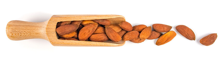 Heap of shelled almond kernels in wooden scoop over white background.