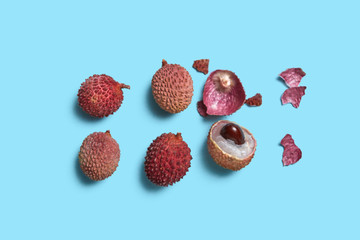 Whole halves and peel lychee fruit on a blue background with space for text. Flat lay